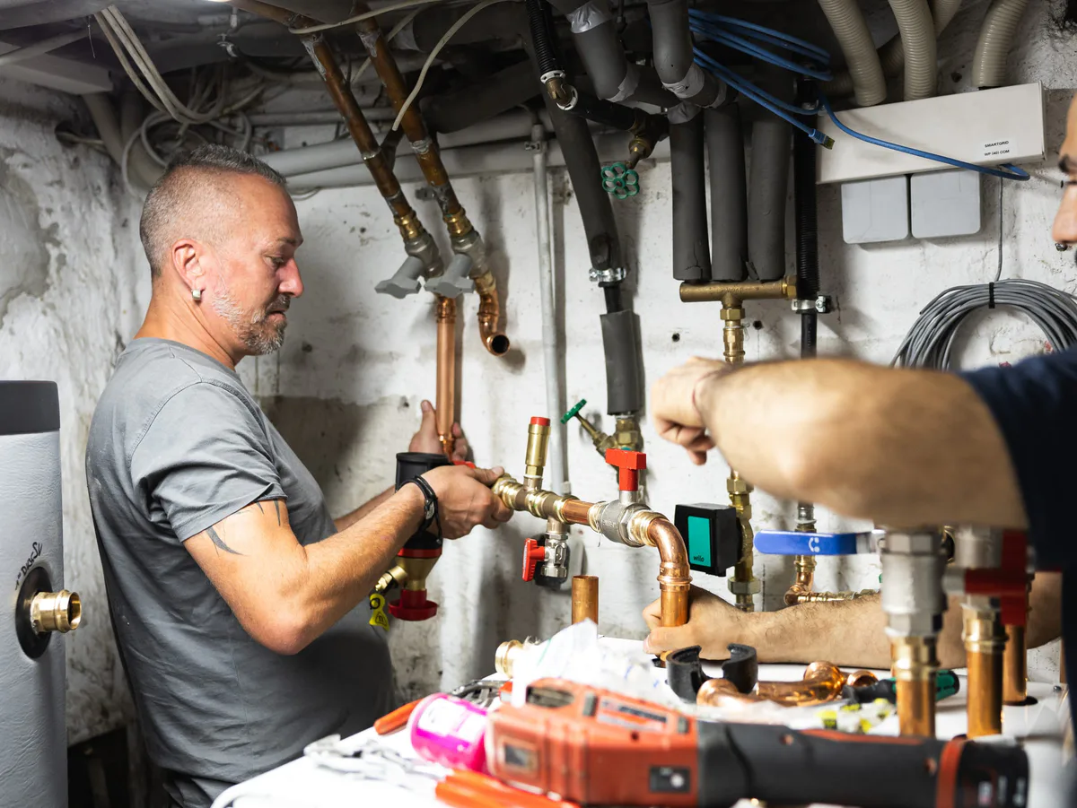 Installateure verlegen im Keller Rohre für eine Wärmepumpe